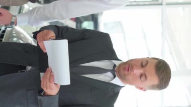 Hoş bir çift araba galerisinden araba alırken müdürle konuşuyor. Araba galerisi. Dikey video