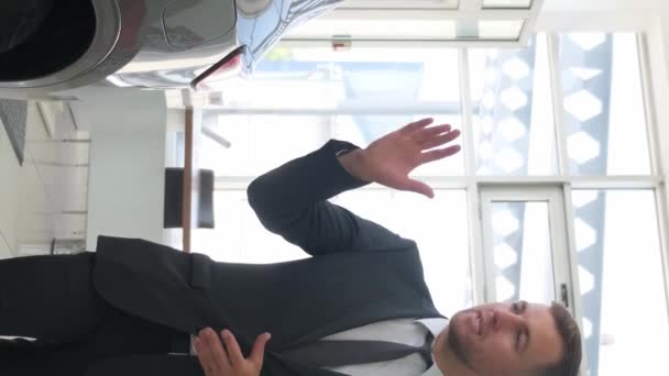 汽车沙龙的一位男经理谈到了新车 汽车经销店的销售 垂直录像 — 图库视频影像