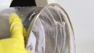 Bir kadın metal bir tavayı yıkıyor. Günlük ev işi kavramı.