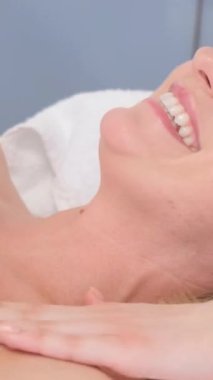 Güzellik salonunda vücut masajı, 40 yaşında bir kadın. Kaplıca merkezinde vücut bakımı. Profesyonel vücut masajı. Dikey video