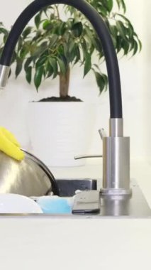 Lokanta mutfağında tavaları yıkarken yakın çekim. Bulaşık konsepti. Dikey video.