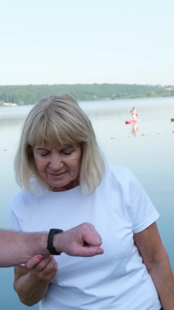 Seniors Talking Lake Using Smart Watch Sports Training Retirement Vertical — Stock Video