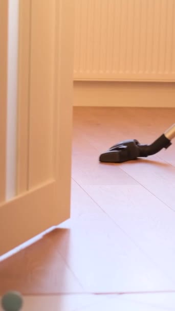 掃除機を使った女性が家の床を掃除 バーティカルビデオ — ストック動画