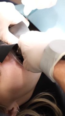 Diş tedavisi sırasında dişçi koltuğunda oturan bir hasta. Yukarıdan bak. Tedavi sırasında hastaların ağzı açıktır. Dikey video