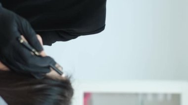 Kalıcı kaş makyajı. Güzellik salonunda tedavi. Bir kozmetik uzmanı kaş düzeltme işlemini gerçekleştirir. Dikey video