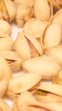 Bir sürü kavrulmuş şam fıstığı meyvesini gösteren tam kare yakın çekim. Lezzetli fıstıklar. Healtii organik gıda. Dikey video