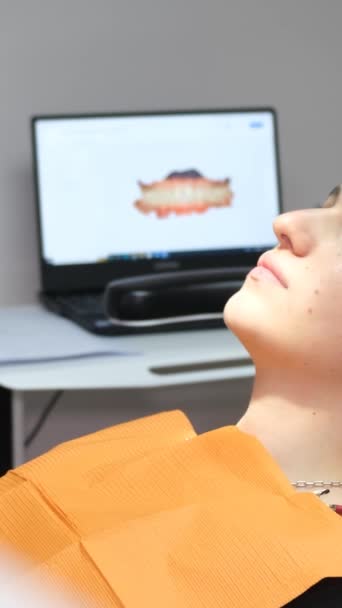 スローモーションビデオ 検査前に歯の椅子にいる若い患者少女 歯のタイムリーな治療 歯医者を訪ねました バーティカルビデオ — ストック動画
