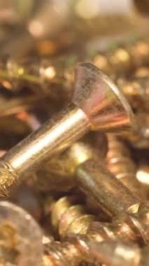 Metal screws in the furniture workshop rotate in a circle. Use of fasteners when working with wood. Macro video