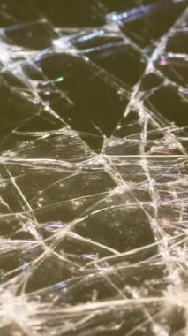 Beyaz ışıkla aydınlatılan kırık camların yakın çekimi. Makro video. Dikey video.