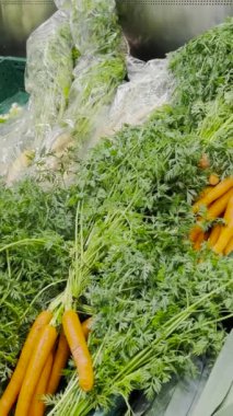 Sebze pazarındaki ürünler, havuç, lahana ve yeşillikler. Vejetaryen yemeği kavramı. Dikey video