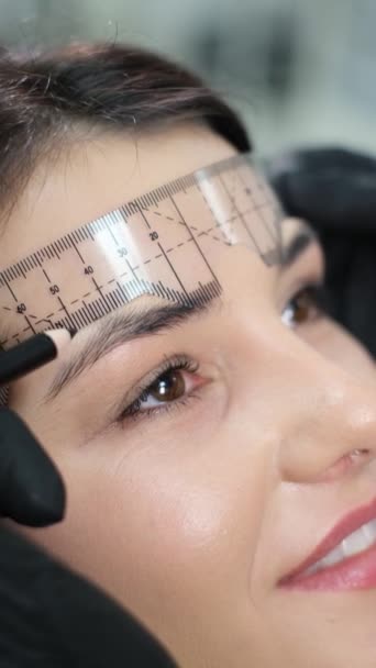 Vídeo Vertical Esteticista Realizando Procedimiento Permanente Maquillaje Cejas Usando Una — Vídeos de Stock