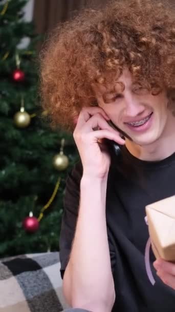 その若者は新年の贈り物を受け取った クリスマスのお祝い 贈り物をする ハッピーな若者 バーティカルビデオ — ストック動画