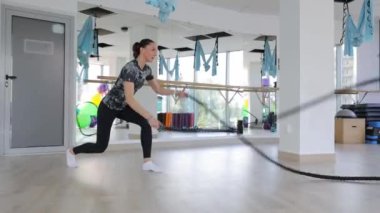 Genç kaslı kadın spor salonunda idman için ip kullanıyor. Spor salonunda dayanıklılık eğitimi, fitness, kilo kaybı..