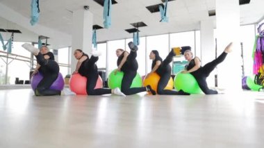 Bir grup insan pilates eğitimi sırasında spor toplarıyla esneme egzersizleri yapıyor. Sağlıklı spor yaşam tarzı, fitness, sağlıklı konsept.
