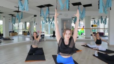 Genç sporcular eğitmenle fitness yapıyor. Bir spor salonunda sağlıklı bir yaşam tarzı sürdüren çok ırklı bir grup kadın. Spor, jimnastik.