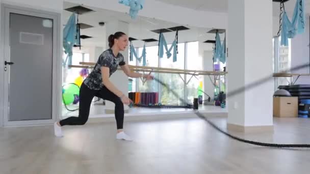 年轻的肌肉女人用绳子在体育馆里训练 减肥方面的力量训练 — 图库视频影像