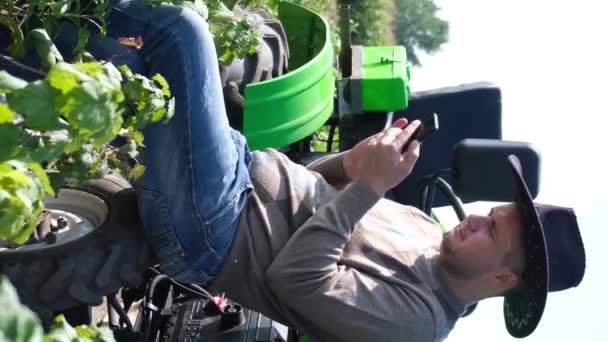 Portrait Jeune Agriculteur Reposant Dans Champ Près Tracteur Utilisant Gadget — Video