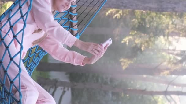 Kobieta Telefonem Spoczywa Hamaku Telefonem Komórkowym Robi Selfie Rozmawia Pionowe — Wideo stockowe