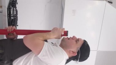 Sahnedeki performansı taklit ederek inşaat çizgisi ile dans edip şarkı söyleyen genç ve mutlu inşaat işçisi. Ev yenileme konsepti. Dikey video