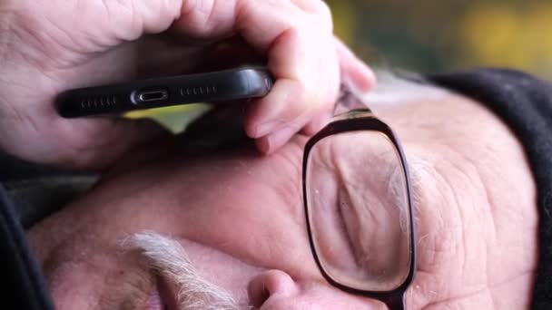Przyjemny Stary Siwowłosy Mężczyzna Okularach Siedzi Ławce Parku Rozmawia Przez — Wideo stockowe