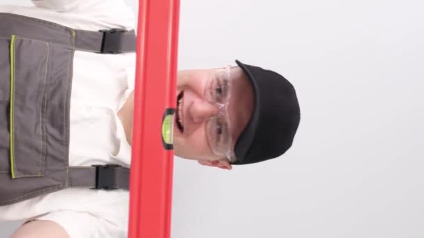 Lächelnder Bauarbeiter Mit Wasserstand Den Händen Atelier Auf Weißem Hintergrund — Stockvideo