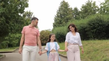Mutlu bir aile, ilk çağrıya koşuşturma, ilkokul eğitimi, okul çantası çocukların omuzlarında. Sevimli küçük bir kız okula döndüğü için çok mutlu..