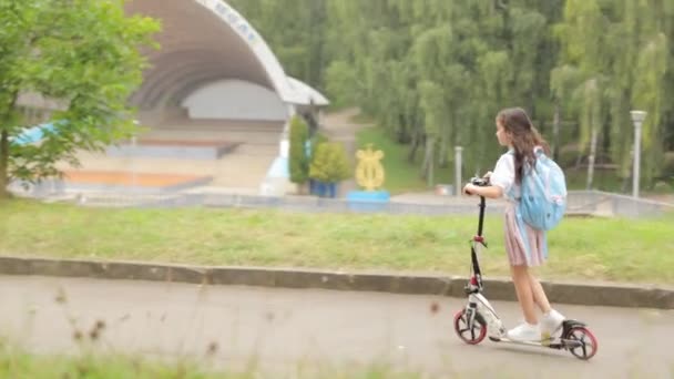 Niña Con Una Mochila Escuela Scooter Vista Trasera Feliz Estilo — Vídeos de Stock