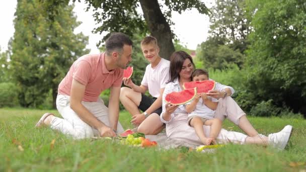 Parkta Piknik Yapan Çocuklu Güzel Bir Çift Bahçede Karpuz Yiyen — Stok video