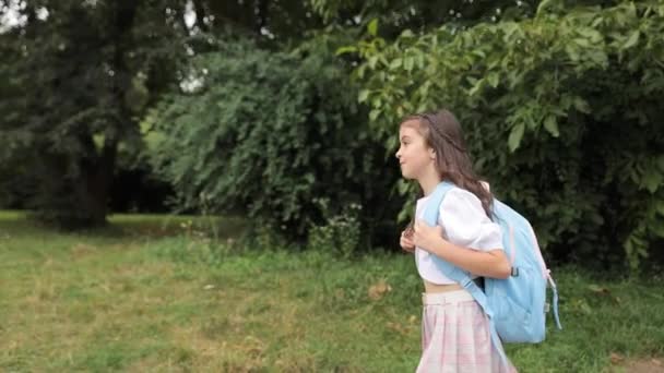 Ein Kleines Mädchen Mit Einem Blauen Rucksack Auf Den Schultern — Stockvideo