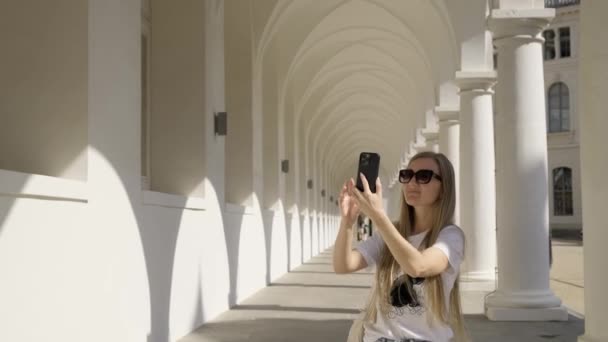 Μια Γυναίκα Ένα Smartphone Στα Χέρια Της Περπατά Στους Όμορφους — Αρχείο Βίντεο