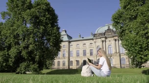 Dışarıdaki Çimlerin Üzerinde Oturan Genç Kız Üniversite Geçmişinde Dizüstü Bilgisayar — Stok video