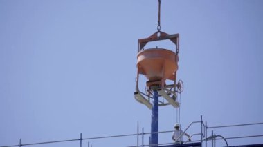 İnşaat işi, yeni bir binaya beton dökmek. Beton karıştırıcı bir vinç tarafından kaldırıldı..