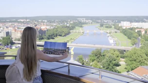 観測デッキにドレスデン市の地図を持っている観光ガール ドイツでの休暇で幸せな女性 ヨーロッパへの旅行 — ストック動画