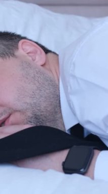 Bir ofis çalışanı evdeki kanepede kestiriyor. Yorgun iş adamı. Dikey video.