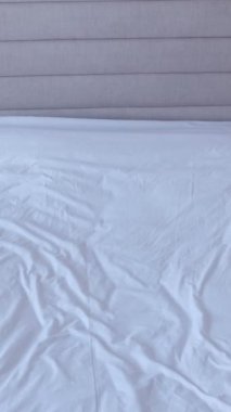 Siyah takım elbiseli bir adam yatak odasındaki bir yatağa düşer. Bir ofis çalışanı yatarken dinlenir. Dikey video