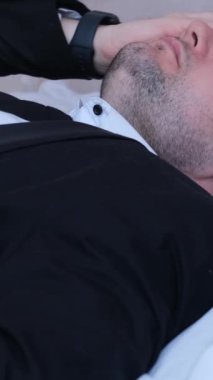 Bir ofis çalışanının partiden sonra başı ağrır. Akşamdan kalma belirtileri. Alkol zehirlenmesi. Dikey video.