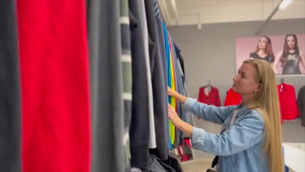Νεαρή Γυναίκα Αγοράζει Μεταχειρισμένα Βιώσιμα Ρούχα Από Δεύτερο Χέρι Φιλανθρωπικό — Αρχείο Βίντεο
