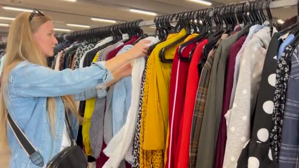 女性は女性の店で服を調べる 割引で服のためのショッピング ブラックフライデー — ストック動画