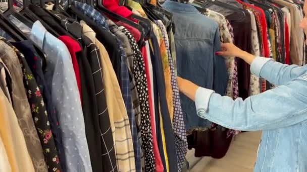 店の女性は割引で服を見ています 服のための秋の割引 服の販売について — ストック動画