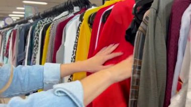 Mağazada elbise, ceket ve süveter alışverişi. Kış kadınlarının moda kıyafetleri. Mağazada indirim.
