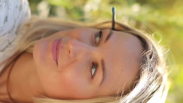 一个美丽的欧洲女人坐在高高的草地上欣赏日落的画像 女人在大自然中休息 垂直录像 — 图库视频影像