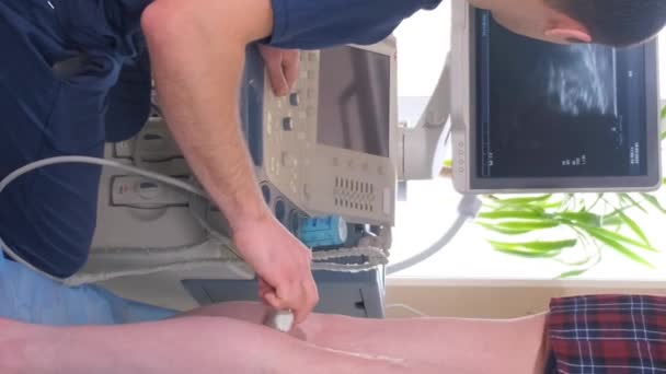 一名超声波医生在他的办公室里检查一个女人的下肢 超声诊断静脉疾病 垂直录像 — 图库视频影像