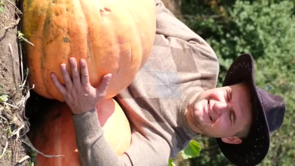Jovem Agricultor Com Sorriso Rosto Abraça Uma Grande Abóbora Amarela — Vídeo de Stock