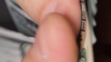 İş adamı el ele tutuşarak dolarları çabucak sayar. Nakit para kavramı. Dikey video.
