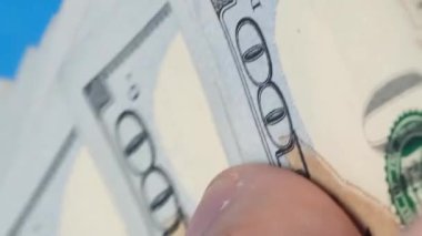 İşadamları 100 dolarlık banknotları hızlıca sayar. Bir adamın elinde nakit para vardır. Dikey video.