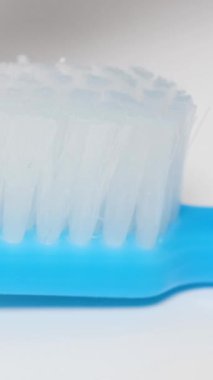 Fırçaya beyaz diş macunu sıkmak, makro video. Sağlıklı diş kavramı. Dikey video