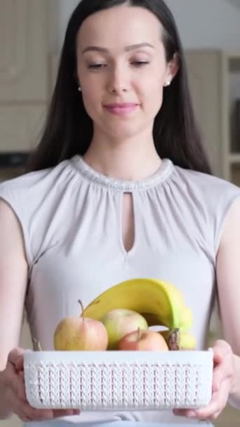 女人笑容满面的笑容散发着她素食生活的积极态度 新鲜的水果 象征着她对健康 减肥和充满活力的生活方式的承诺 垂直录像 — 图库视频影像