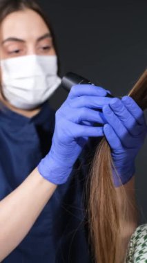 Bir tricholog bir insanı muayene eder. Doktor saçın yapısını teşhis ediyor. Bir dermatologla görüşeceğim. Dikey video.