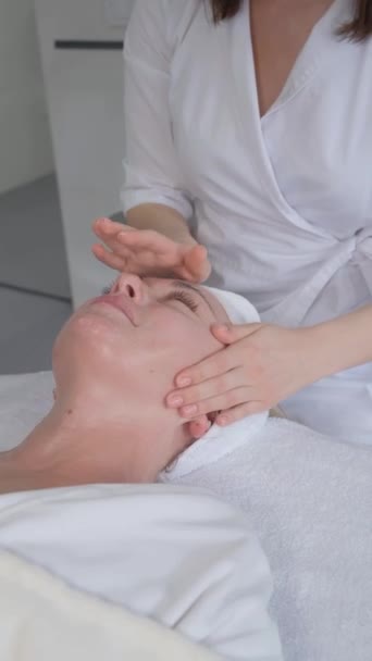 Vertical Video Beautician Pleasantly Massages Womans Face Aging Facial Massage — стокове відео