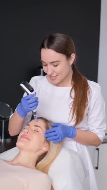 Cosmetólogo Realiza Masaje Facial Eléctrico Para Cliente Una Mujer Salón — Vídeo de stock